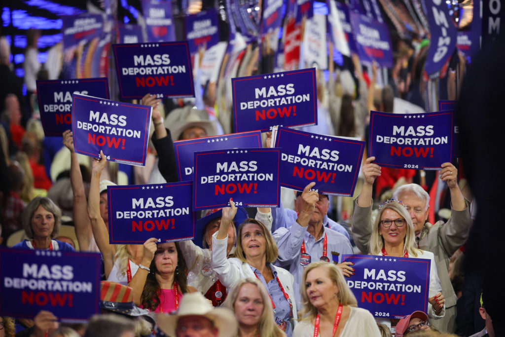 RNC attendees holding up signs calling for mass deportations. 