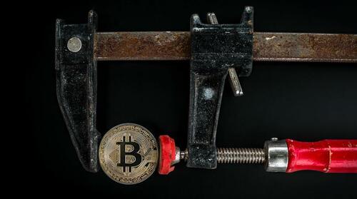 A Bitcoin in a vice. 