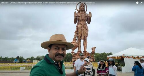 A YouTuber poses in front of the giant statue of Hanuman, the Hindu monkey god, in Sugarland Texas. 