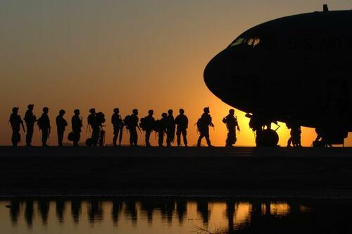 Soldiers getting on a cargo plane. 