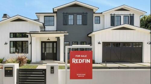A Redfin for sale sign in front of a house. 