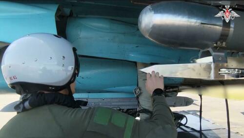 A Russian Su-34 pilot inspects a glide bomb.