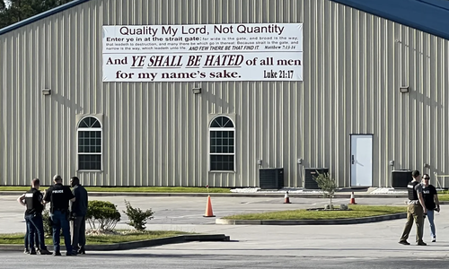 Police outside a large church building with metal siding