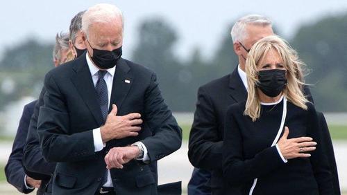 Biden checks watch during "dignified transfer ceremony" to honor fallen servicemembers.