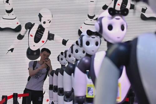 Un homme prend une photo de robots lors de la conférence mondiale sur 
l'intelligence artificielle à Shanghai, le 7 juillet 2023. (Wang Zhao/AFP via Getty Images)